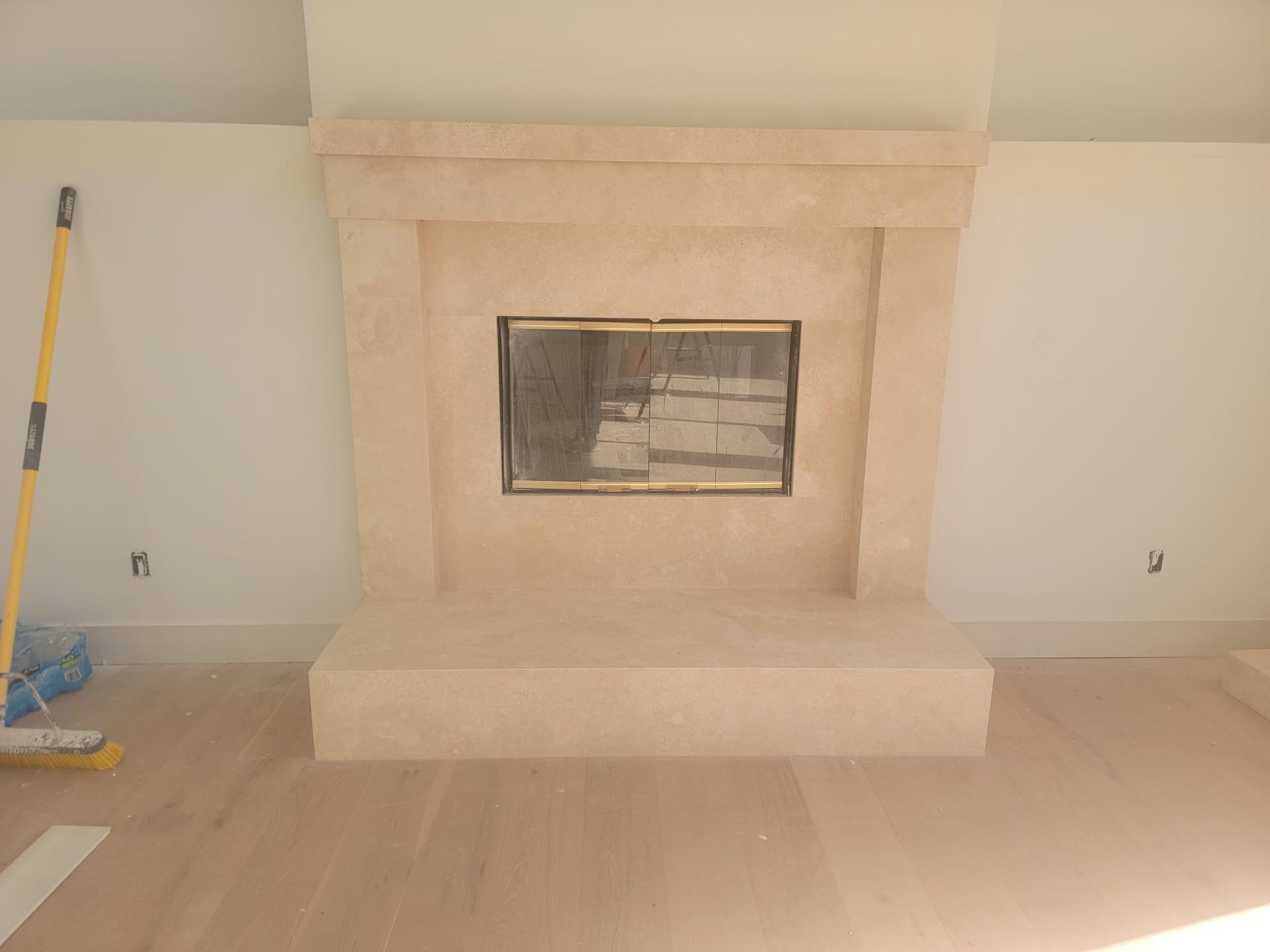 Natural limestone fireplace surround and raised hearth installation — custom stone work by Matthew Suncoast